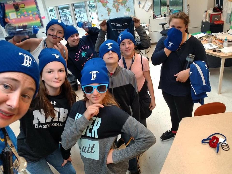 middle school students and teacher wearing blue TF hats