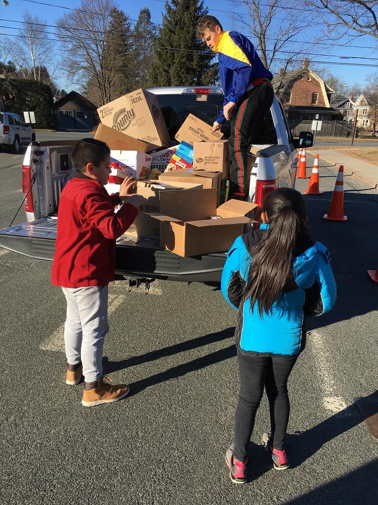 stuents loading food donations onto a pickup truck
